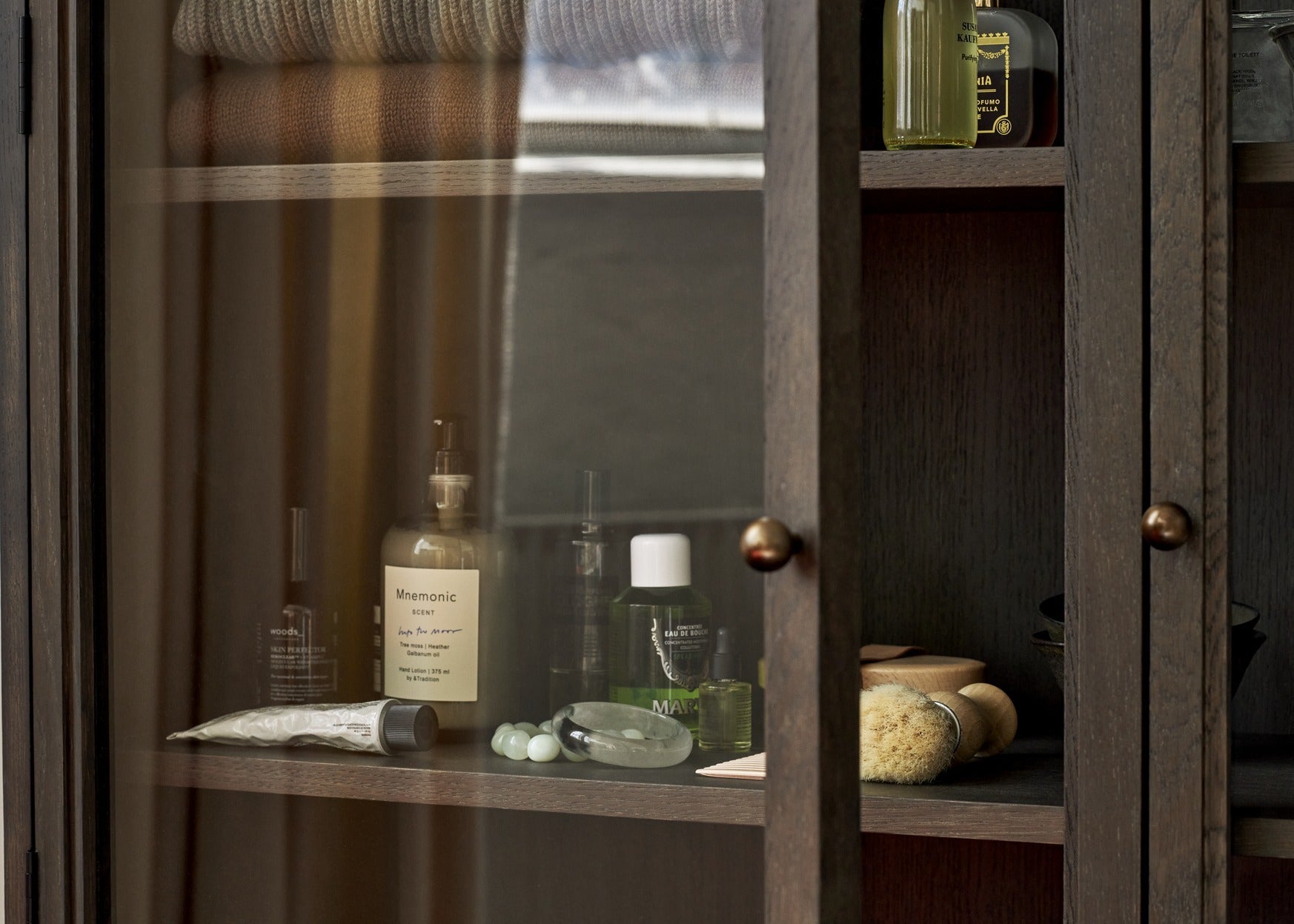 Vitrina &Tradition Trace Double Cabinet SC88 en roble macizo con puertas de cristal y detalles de latón por Space Copenhagen; Trace Double Cabinet SC88 — ATD_Retail_2023_Trace SC88_Inland AV21_Tung JA3_Collect Rug SC84; Trace Double Cabinet SC88 — ATD_Retail_2023_Trace SC88_Mnemonic MNC1; Trace Double Cabinet SC88 — ATD_Retail_2023_Develius EV1C_Trace SC88_The Moor AP5_Formakami JH5; Trace Double Cabinet SC88 — Trace SC88_Dark Stained Oak_detail_2