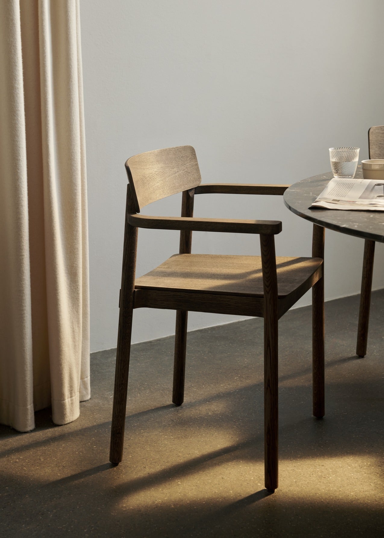 Sillón Betty TK10 de &Tradition en madera maciza con respaldo curvado y brazos ergonómicos, diseño nórdico contemporáneo; Betty Armchair TK10 — Betty TK10_Smoked oak_angled front; Betty Armchair TK10 — Betty TK10_Clear lacquered oak_front angled; Betty Armchair TK10 — Betty TK10_Black_detail; Betty Armchair TK10 — ATD_Retail_2024_Betty TK10_Collect glass SC78
