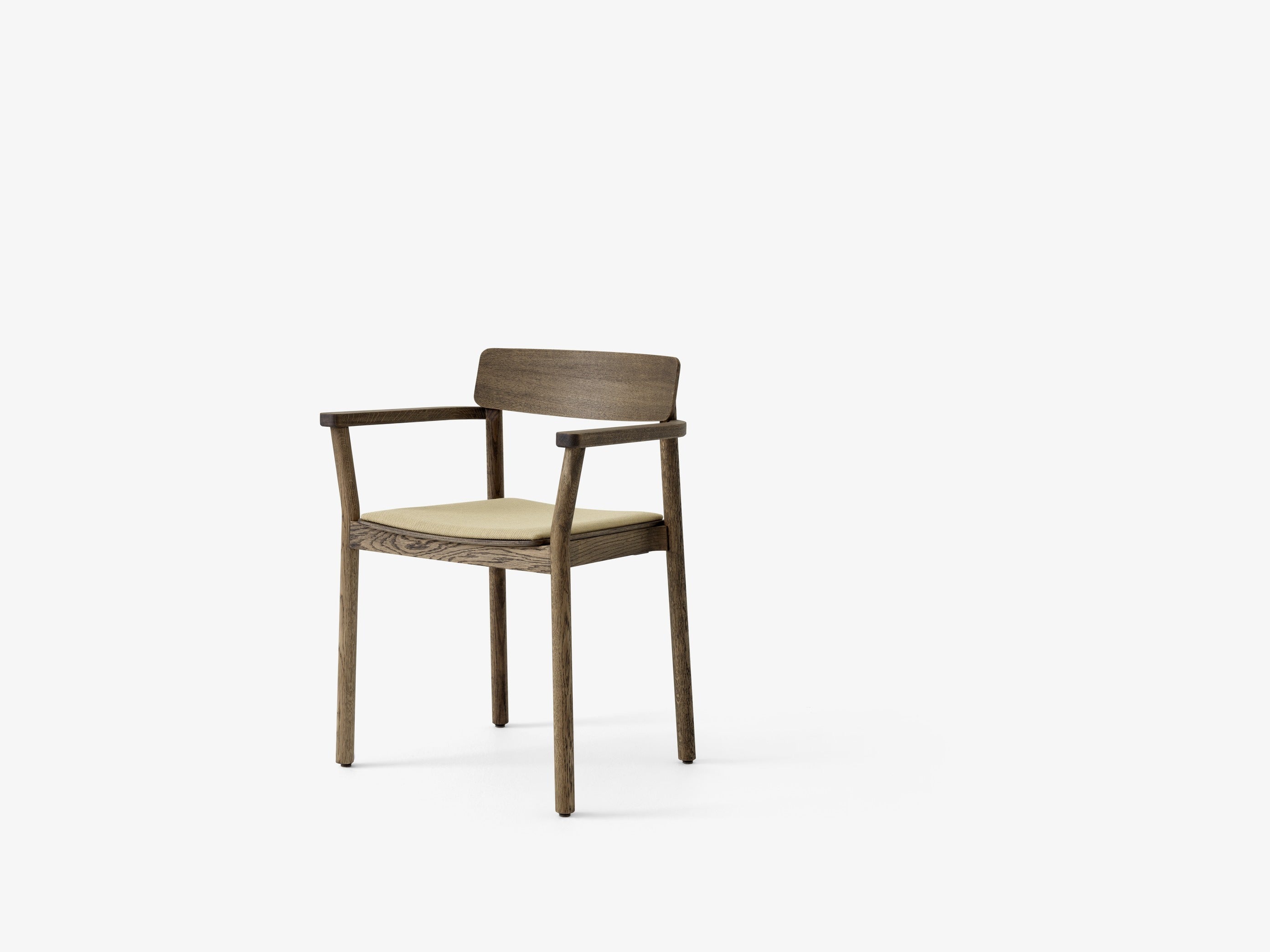 Butaca Betty TK11 de &Tradition en madera maciza con tapizado, diseño nórdico moderno de Thau & Kallio sobre fondo neutro; Betty Armchair TK11 — Betty TK11_Smoked oak w. Fiord 0571_angled front; Betty Armchair TK11 — Betty TK11_Clear lacquered oak w. sisu 0655_angled front; Betty Armchair TK11 — Betty TK11_Smoked oak w. Fiord 0422_angled front; Betty Armchair TK11 — Betty TK11_Black lacquered oak w. noble black leather_ angled front