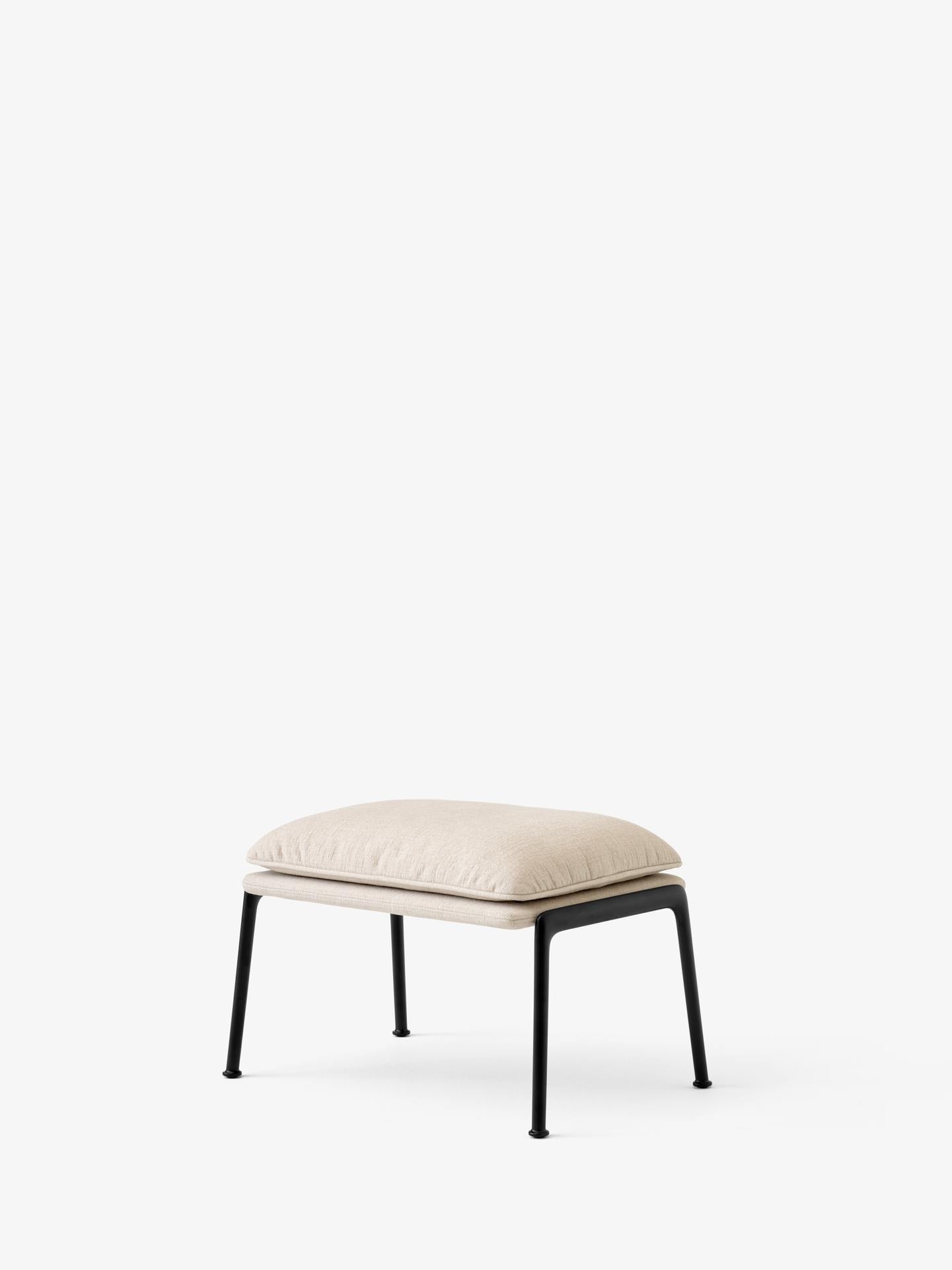 Reposapiés &Tradition Muno LN20 de Luca Nichetto con estructura de aluminio y tapizado contemporáneo sobre fondo neutro; Muno Footstool LN20 — Muno Footstool LN20_Warm Black Legs w. Clay 0007_Angled Front; Muno Footstool LN20 — Muno Footstool LN20_Warm Black Legs w. Cifrado 0221_Angled Front; Muno Footstool LN20 — Muno Footstool LN20_Warm Black Legs w. Noble Leather Black_Angled Front; Muno Footstool LN20 — Muno Footstool LN20_Warm Black Legs w. Ecriture 0780_Angled Front