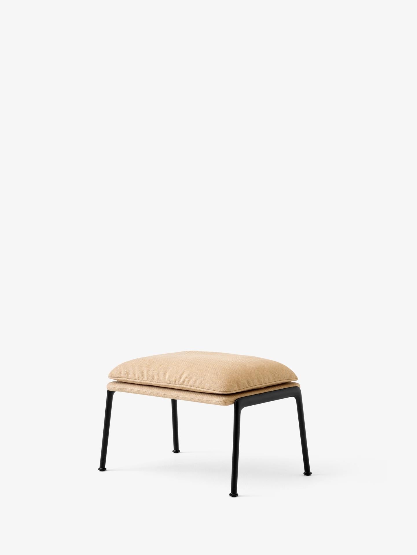 Reposapiés &Tradition Muno LN20 de Luca Nichetto con estructura de aluminio y tapizado contemporáneo sobre fondo neutro; Muno Footstool LN20 — Muno Footstool LN20_Warm Black Legs w. Clay 0007_Angled Front; Muno Footstool LN20 — Muno Footstool LN20_Warm Black Legs w. Cifrado 0221_Angled Front; Muno Footstool LN20 — Muno Footstool LN20_Warm Black Legs w. Noble Leather Black_Angled Front; Muno Footstool LN20 — Muno Footstool LN20_Warm Black Legs w. Ecriture 0780_Angled Front