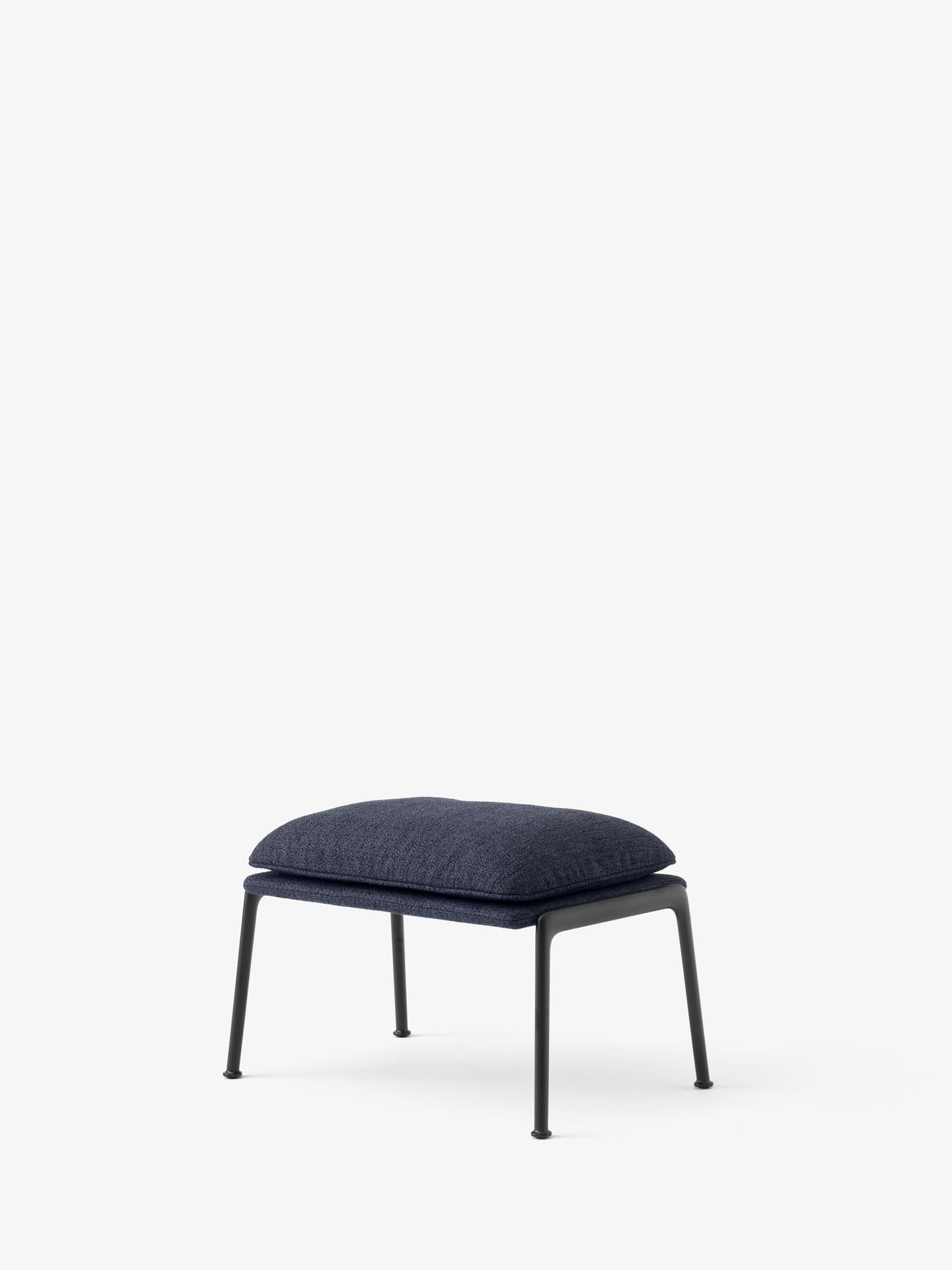 Reposapiés &Tradition Muno LN20 de Luca Nichetto con estructura de aluminio y tapizado contemporáneo sobre fondo neutro; Muno Footstool LN20 — Muno Footstool LN20_Warm Black Legs w. Clay 0007_Angled Front; Muno Footstool LN20 — Muno Footstool LN20_Warm Black Legs w. Cifrado 0221_Angled Front; Muno Footstool LN20 — Muno Footstool LN20_Warm Black Legs w. Noble Leather Black_Angled Front; Muno Footstool LN20 — Muno Footstool LN20_Warm Black Legs w. Ecriture 0780_Angled Front