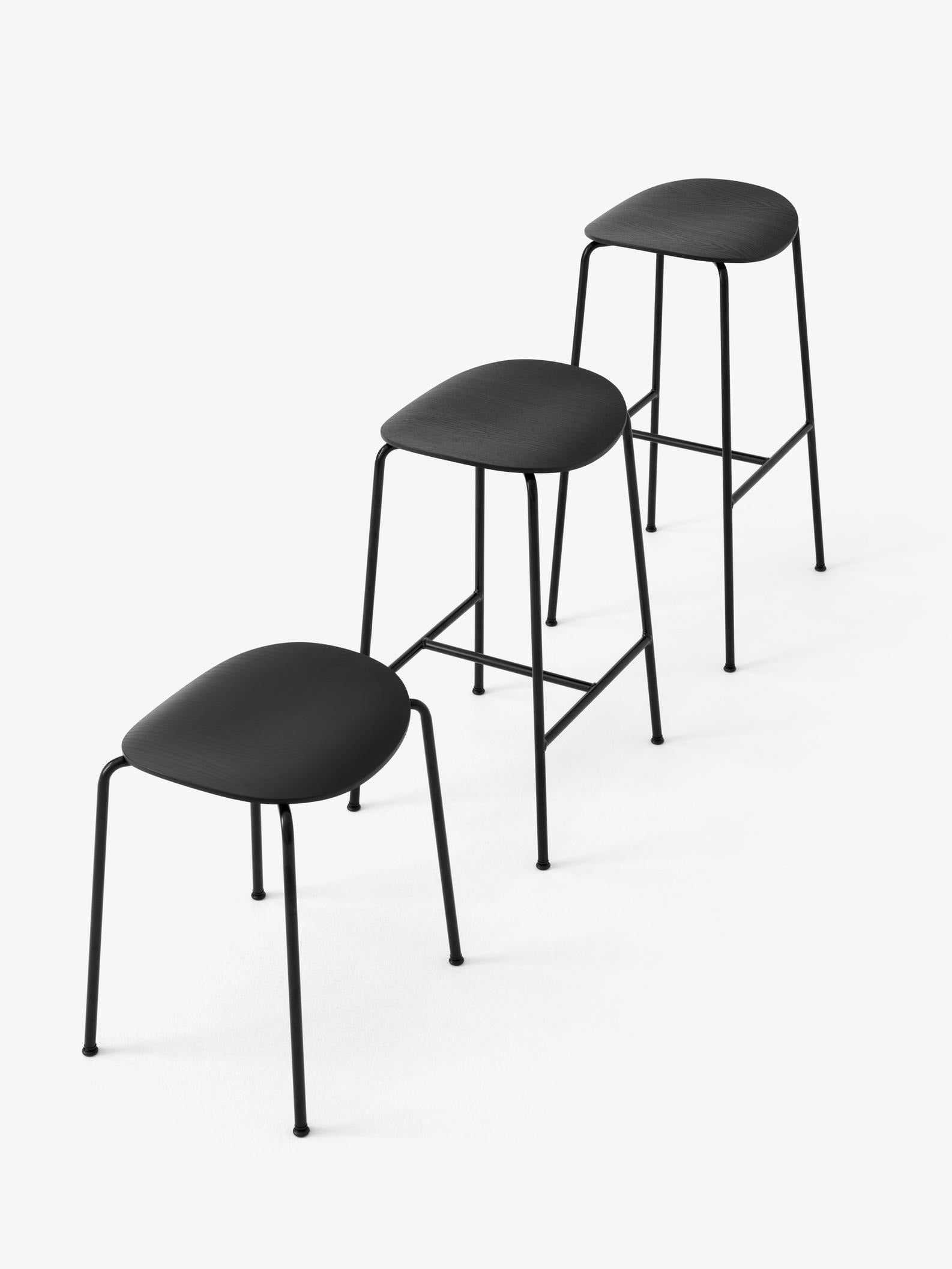 Taburete Pavilion AV36 de &Tradition con estructura de tubos de acero y asiento de chapa de madera moldeada, diseño minimalis; Pavilion Stool AV36 — Pavilion Stool AV36_Black Frame_Black Lacquered Oak_Angled Front; Pavilion Stool AV36 — Pavilion Stool AV36_Black Frame_Lacquered Oak_Angled Front; Pavilion Stool AV36 — Pavilion AV36 AV37 AV38_Black Frame_Black Lacquered Oak_Family; Pavilion Stool AV36 — Pavilion AV36 AV37 AV38_Black Frame_Lacquered Oak_Family