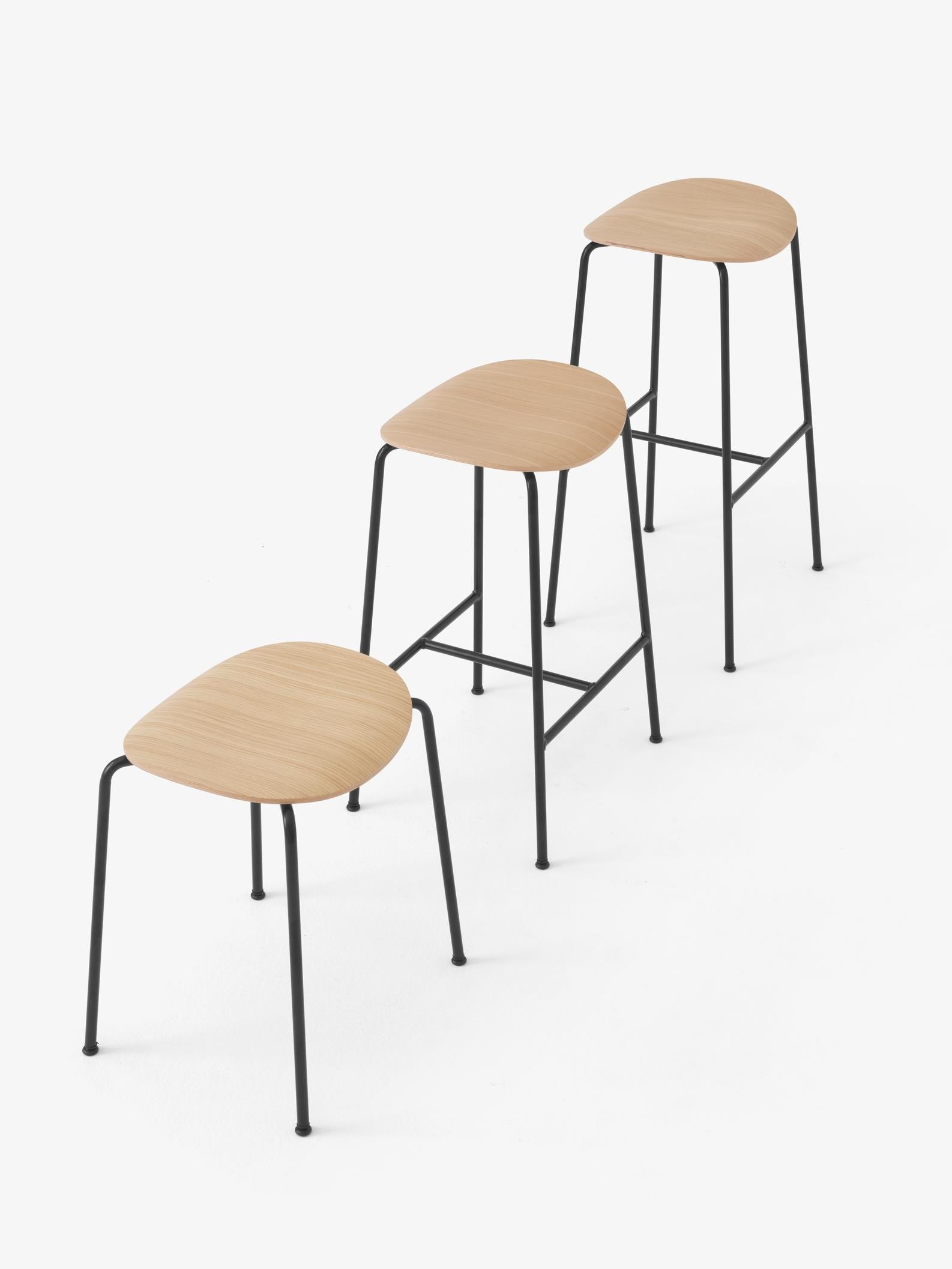 Taburete Pavilion AV36 de &Tradition con estructura de tubos de acero y asiento de chapa de madera moldeada, diseño minimalis; Pavilion Stool AV36 — Pavilion Stool AV36_Black Frame_Black Lacquered Oak_Angled Front; Pavilion Stool AV36 — Pavilion Stool AV36_Black Frame_Lacquered Oak_Angled Front; Pavilion Stool AV36 — Pavilion AV36 AV37 AV38_Black Frame_Black Lacquered Oak_Family; Pavilion Stool AV36 — Pavilion AV36 AV37 AV38_Black Frame_Lacquered Oak_Family